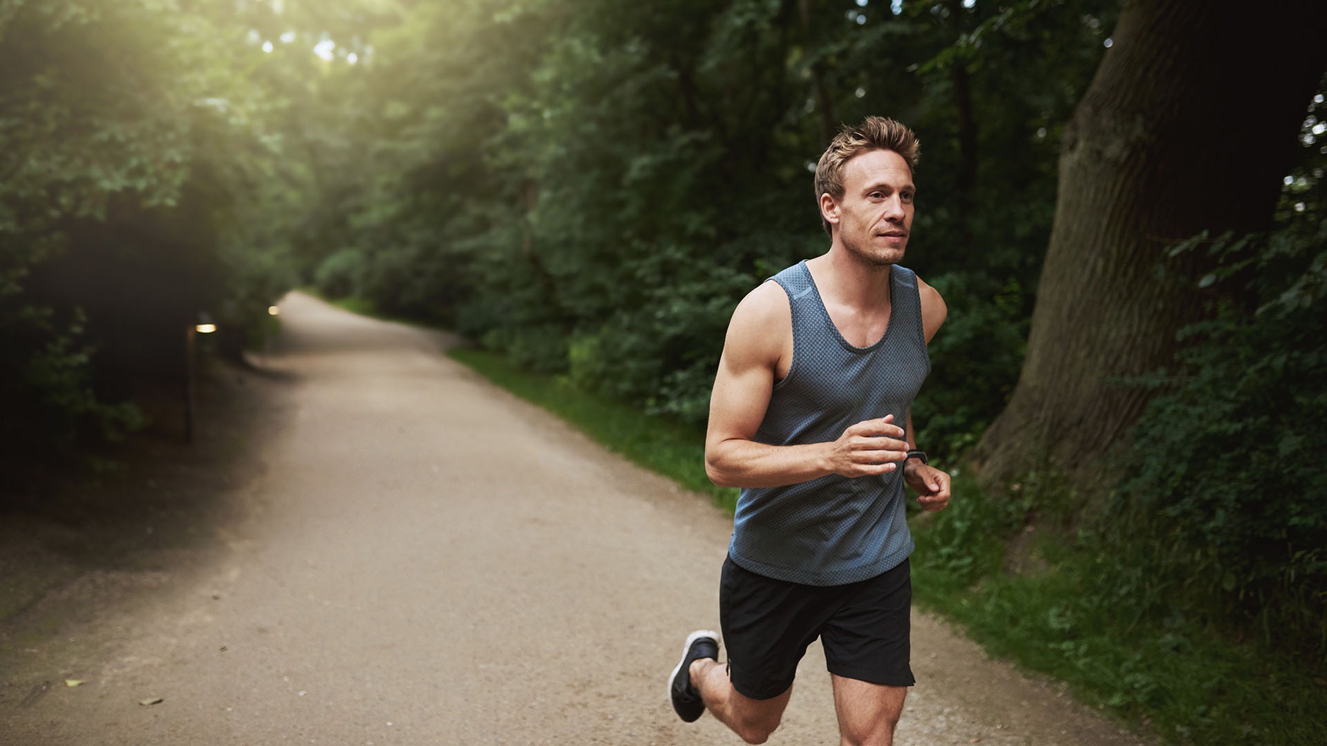 Three Quarter Shot of an Athletic Young Man Doing an Outdoor Running Exercise at the Park