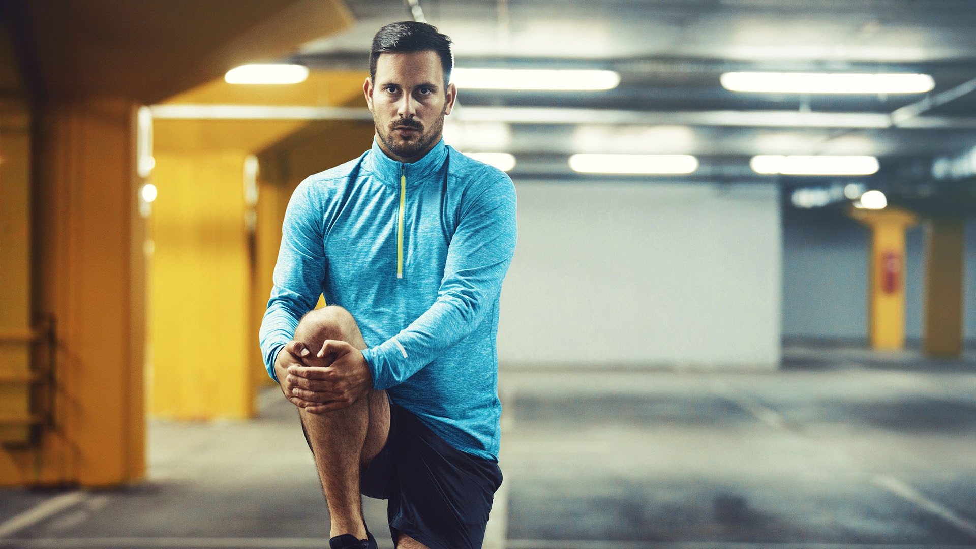 Young athlete man is exercising in garage.