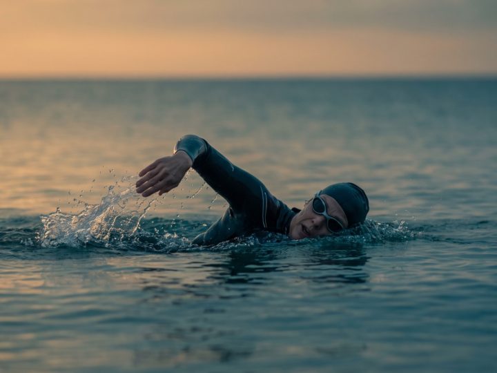 Woman swimming in open water at sunrise off the San Diego coast