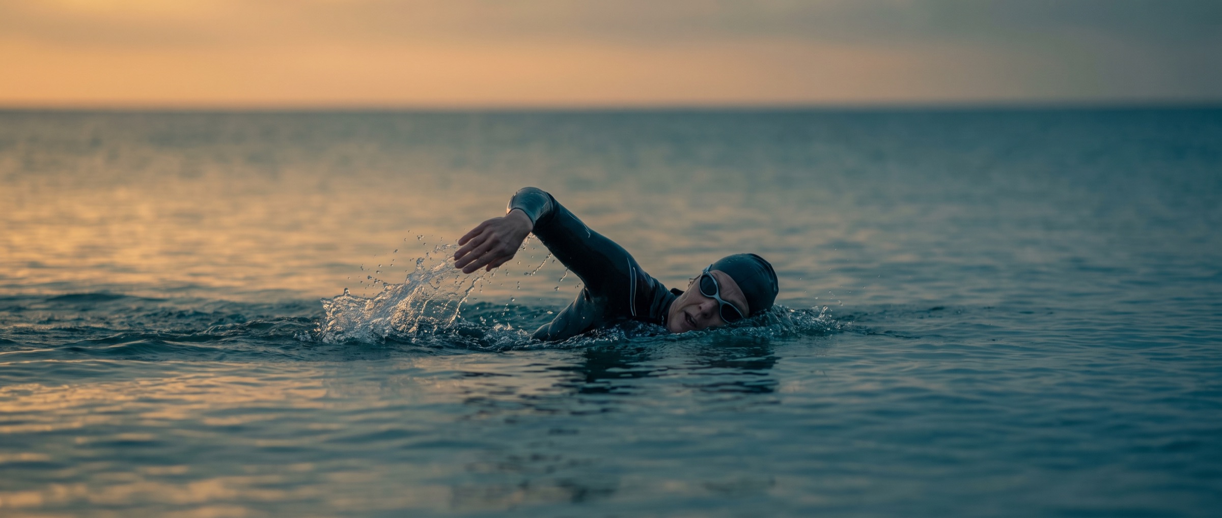 Woman swimming in open water at sunrise off the San Diego coast