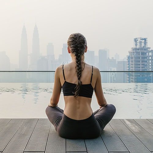 Relaxed young yoga woman in yoga pose near pool. Yoga Concept.